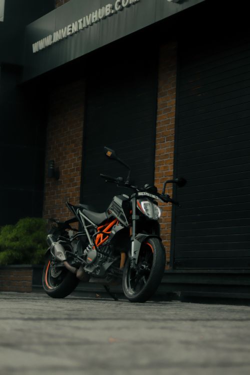 Free A sleek motorcycle parked in an urban setting against a brick wall, ideal for mobile wallpaper. Stock Photo