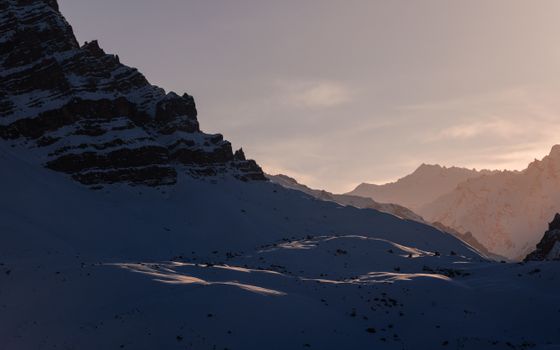 Tranquil winter scene of snow-covered mountains at sunrise in Kibber, India.