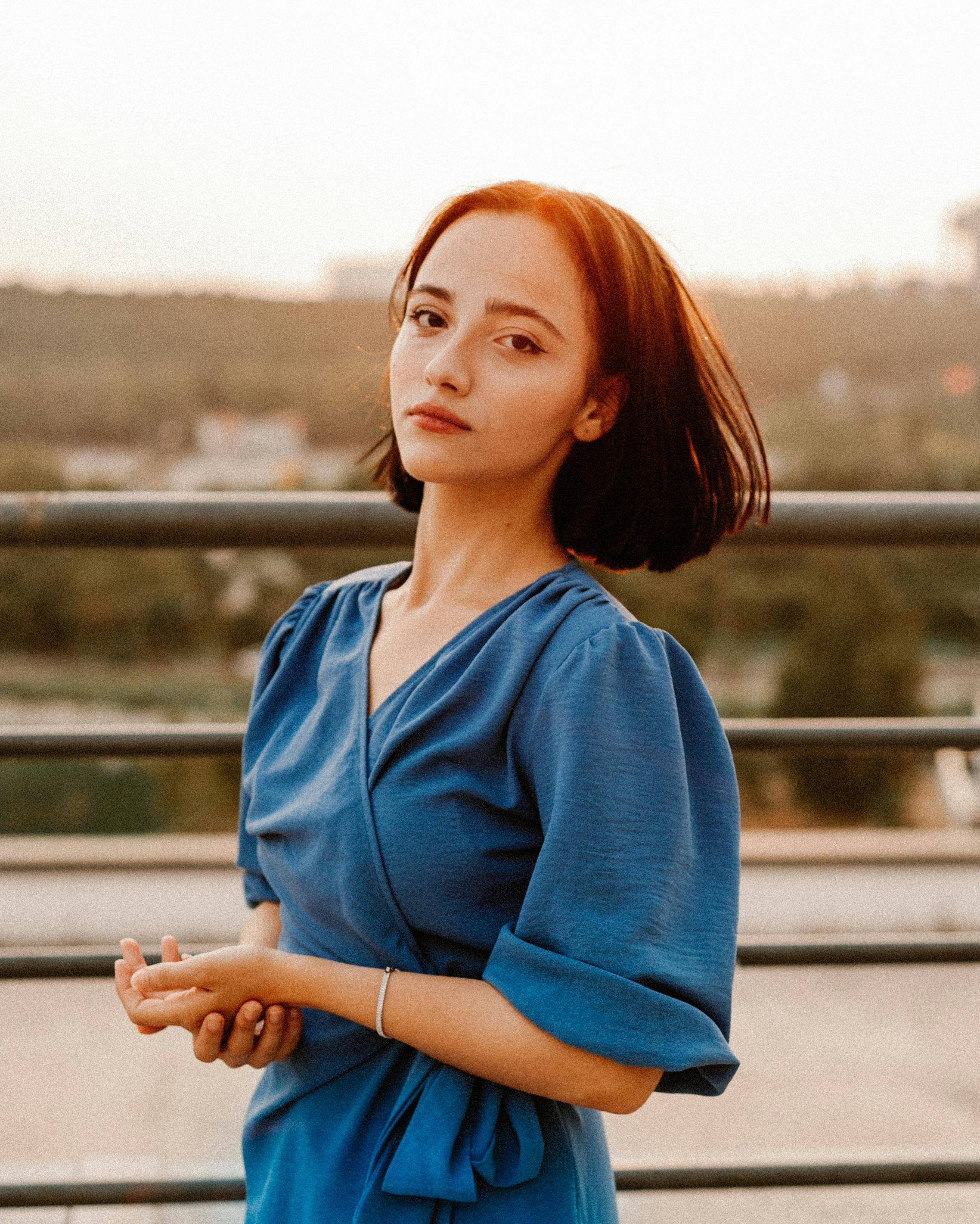 Portrait of a woman posing by railings in Istanbul, capturing serene elegance at sunset.