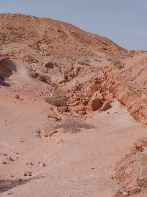 Free A serene desert landscape featuring sandy dunes and rocky formations under a clear sky. Stock Photo