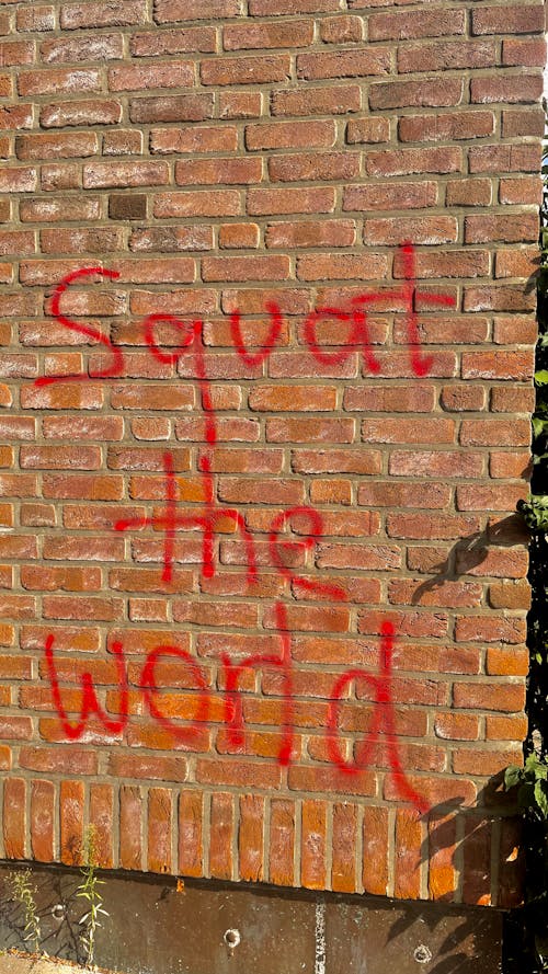 Free Confusing Graffiti on Brick Wall in Red Paint Offers Ominous Warning Stock Photo