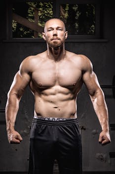 Confident young bodybuilder showing muscles in a gym setting.