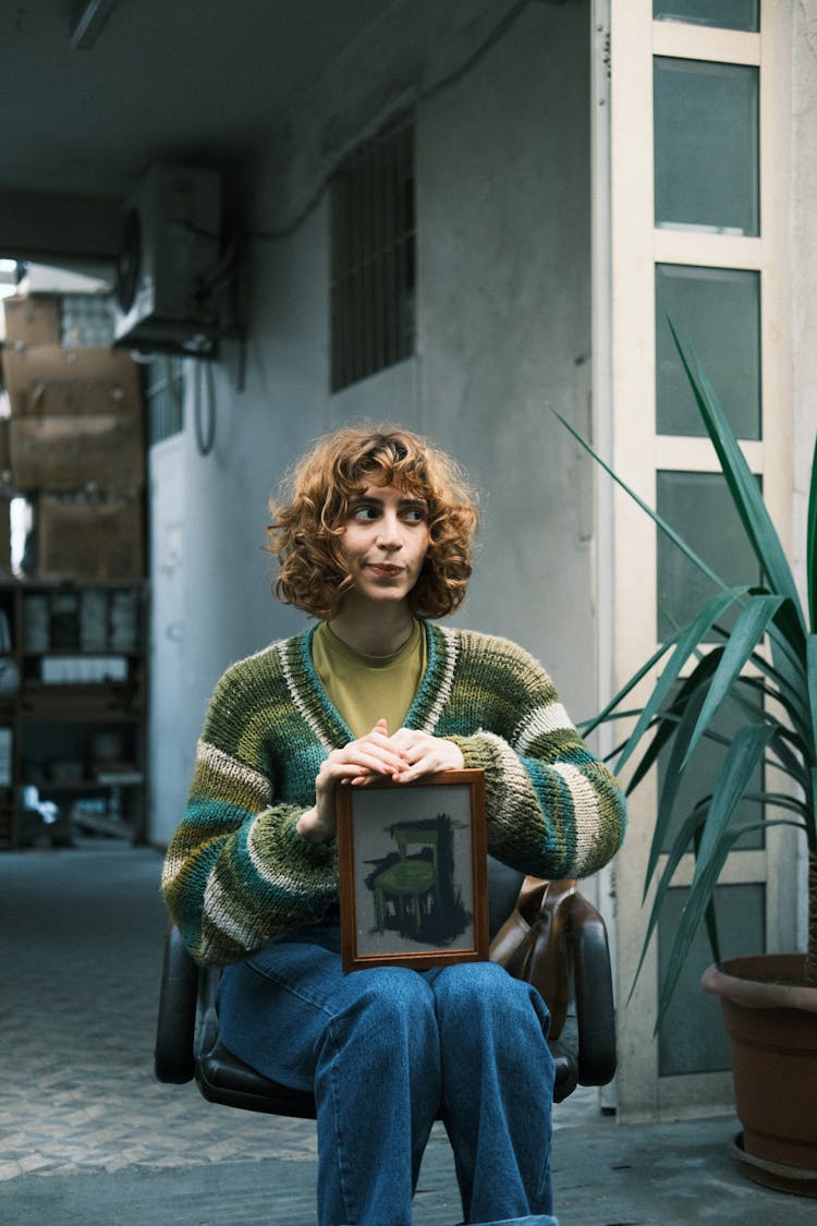 Woman Sitting In Chair With Framed Picture On Her Knees