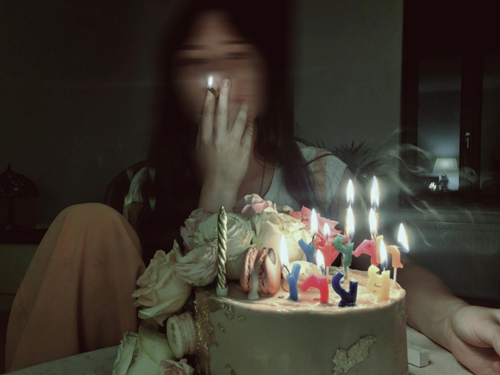 A woman sitting in front of a cake with candles