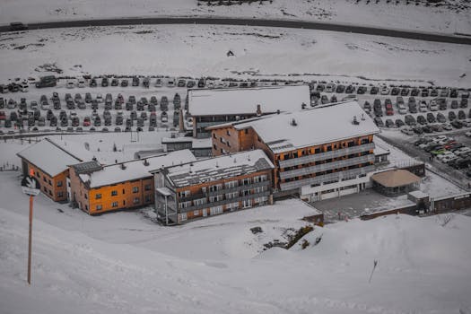 Aerial view of a snow-covered ski resort with a full parking lot, highlighting winter scenery.