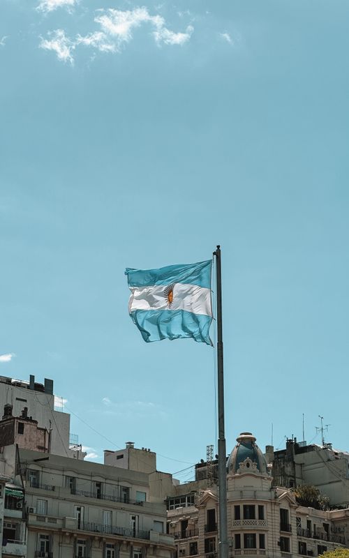 Free Captivating view of the Argentinian flag waving against a clear blue sky in Buenos Aires. Stock Photo
