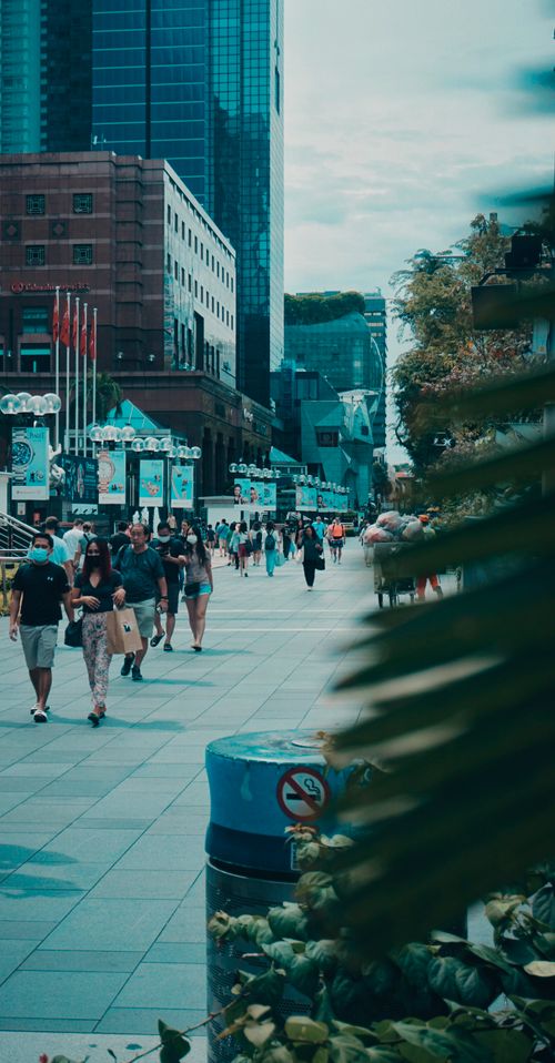 Free A lively city street scene with people walking among modern skyscrapers and shops. Stock Photo