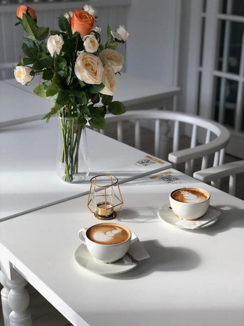 Coffee Cups and Flowers on White Table