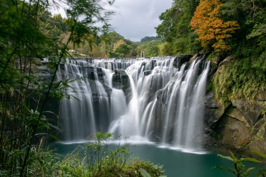 Beautiful long exposure of Shifen Waterfall surrounded by lush greenery.