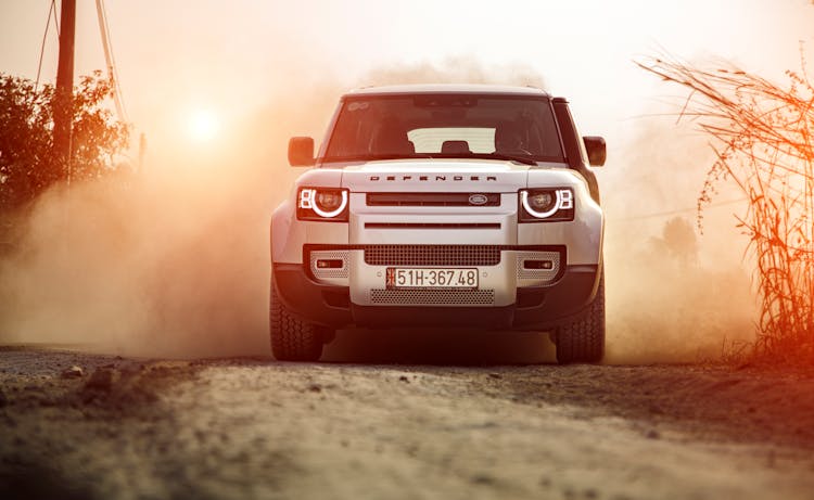 A White Land Rover Defender On Dirt Road