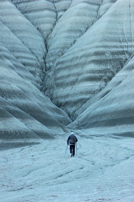 Lone hiker climbing rugged, snowcapped mountain for adventure and exploration.