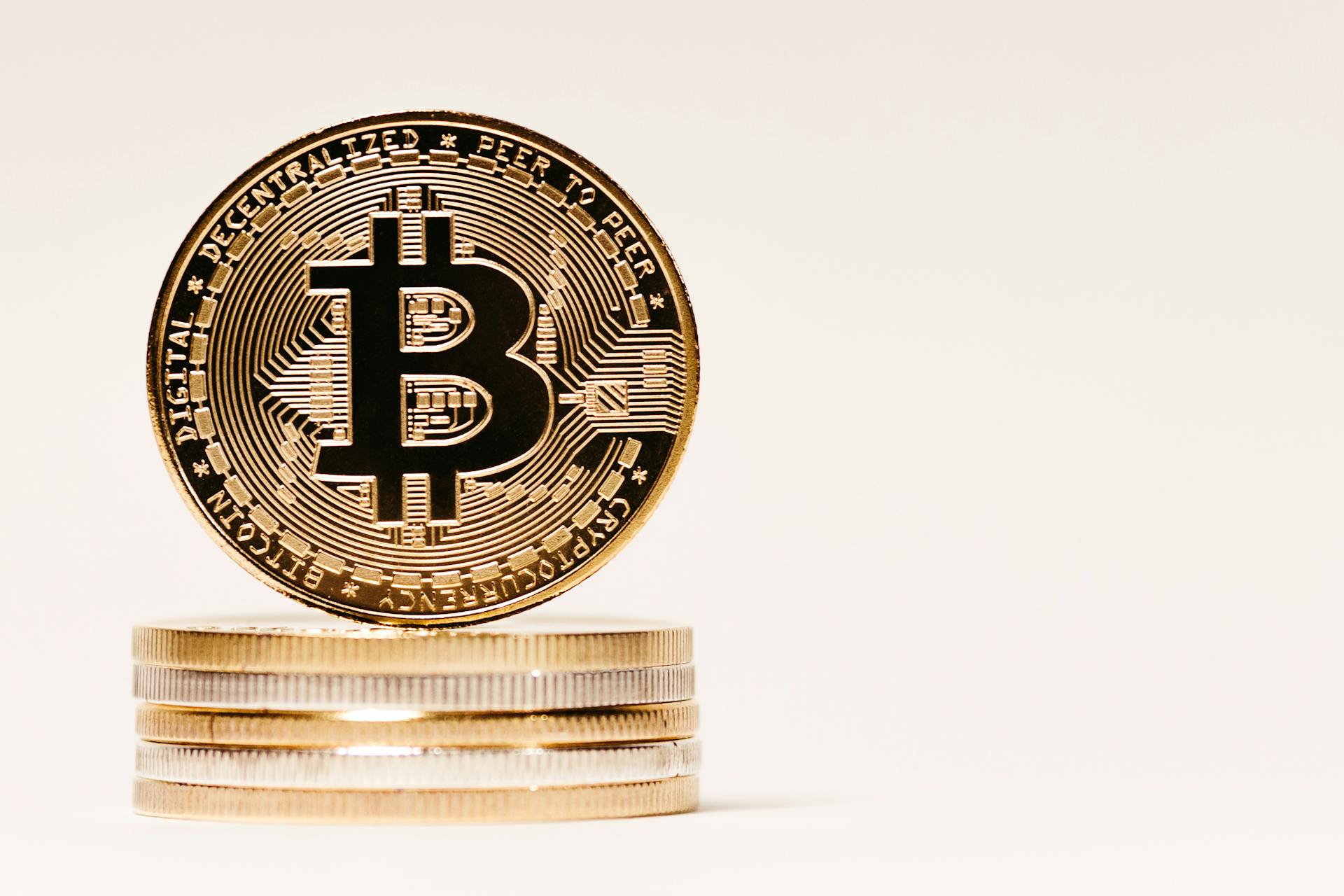 A close-up image of Bitcoin cryptocurrency coins stacked on a neutral background, perfect for financial themes.