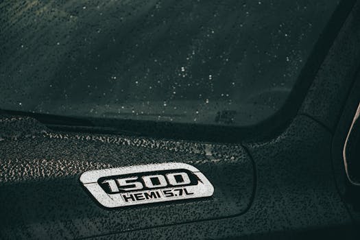 A close-up of a black Dodge Ram 1500 Hemi with rain droplets on the surface, showcasing automotive design.
