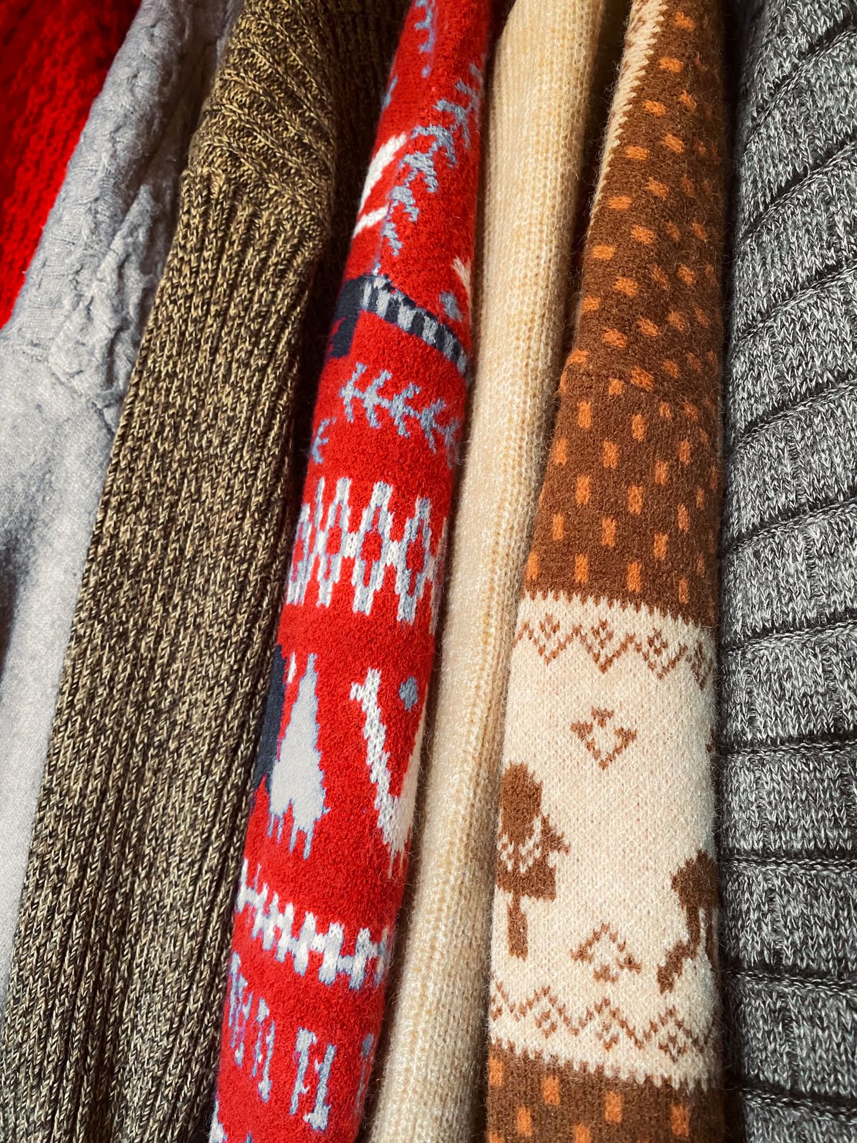 Knitwear hanging in an open wardrobe