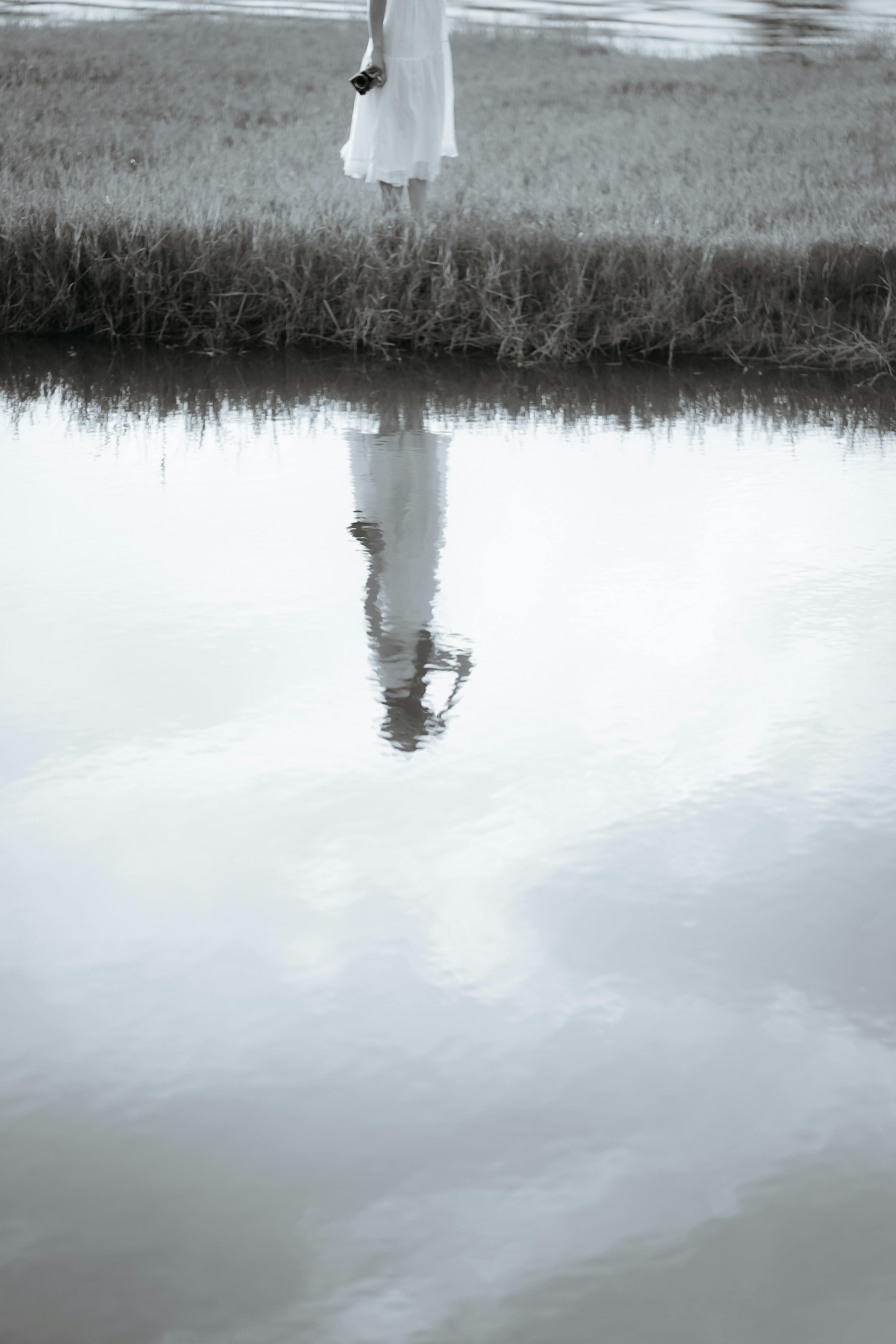 Reflection of Woman in White Dress in Water Free Stock Photo