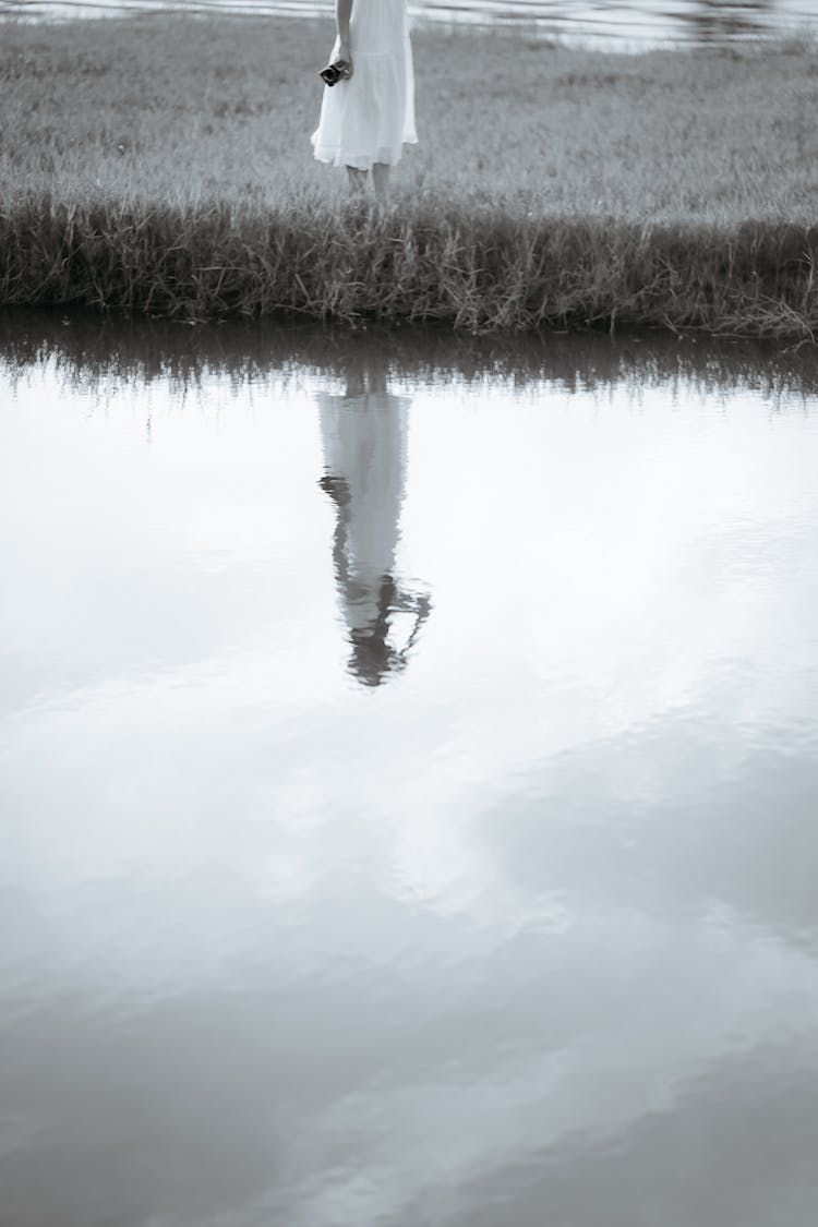 Reflection Of Woman In White Dress In Water