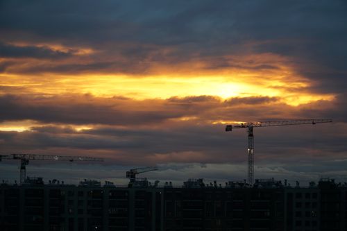 Free Dramatic sunset view with cranes over a construction site in Saint Petersburg, Russia. Stock Photo