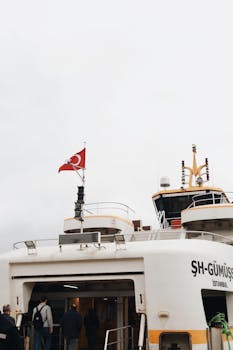 Turkish ferry docked at Istanbul port, showcasing the national flag and active passengers boarding.