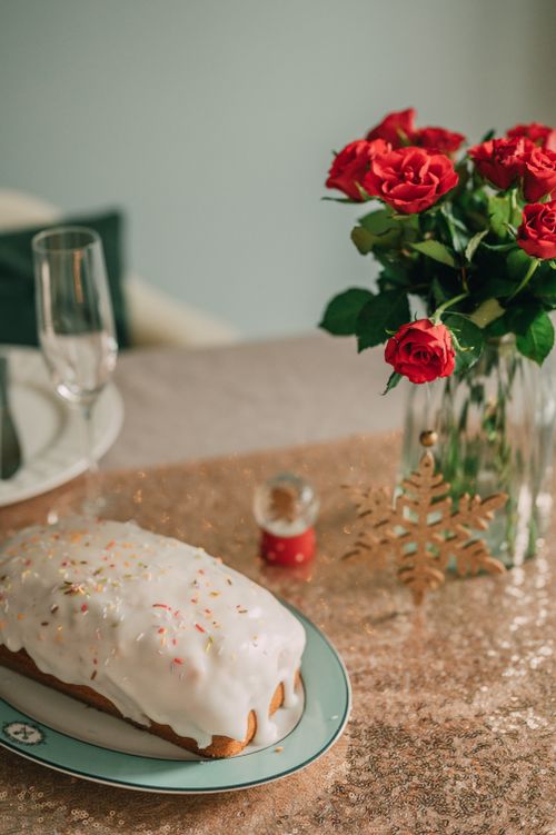 Free Elegant holiday table with roses, iced cake, and festive decor. Stock Photo