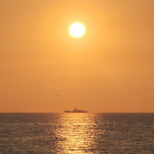 Ship on Horizon at Golden Sunset