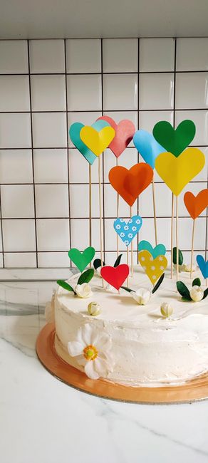 Colorful heart-decorated cake with creamy frosting, ideal for celebrations and parties.