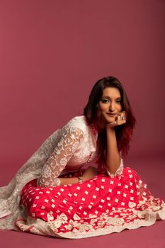 Portrait of a smiling woman in a vibrant traditional dress, exuding elegance and confidence.