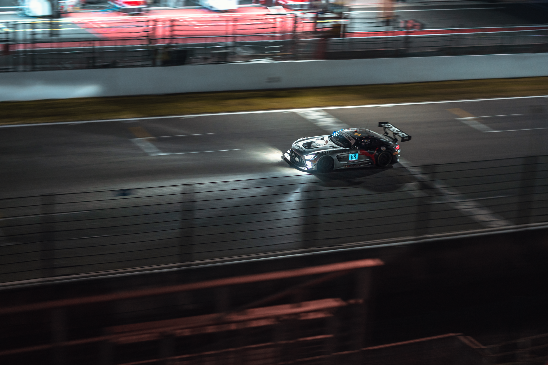 Race cars speeding around the Circuit de la Sarthe at the 24 Hours of Le Mans.