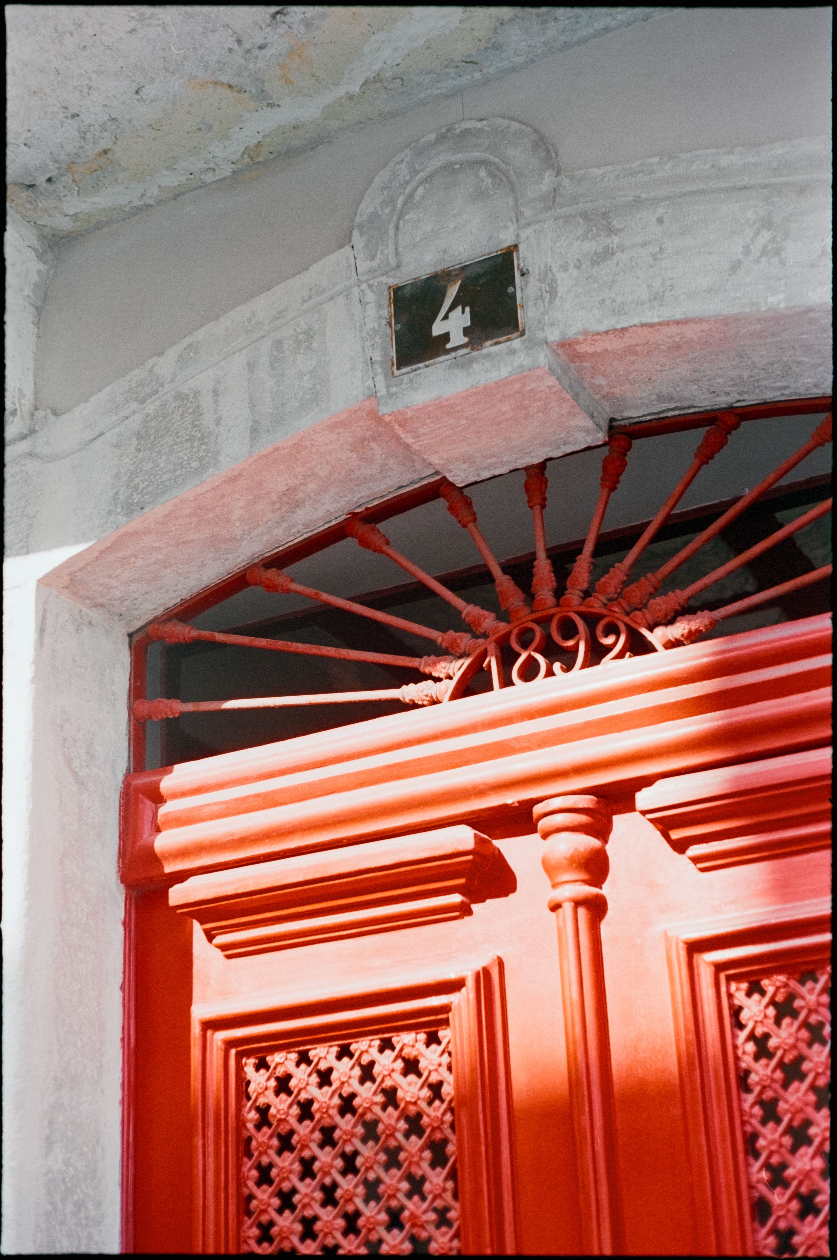 Close-up of a vintage red door with intricate details, photographed in Lisbon, Portugal.