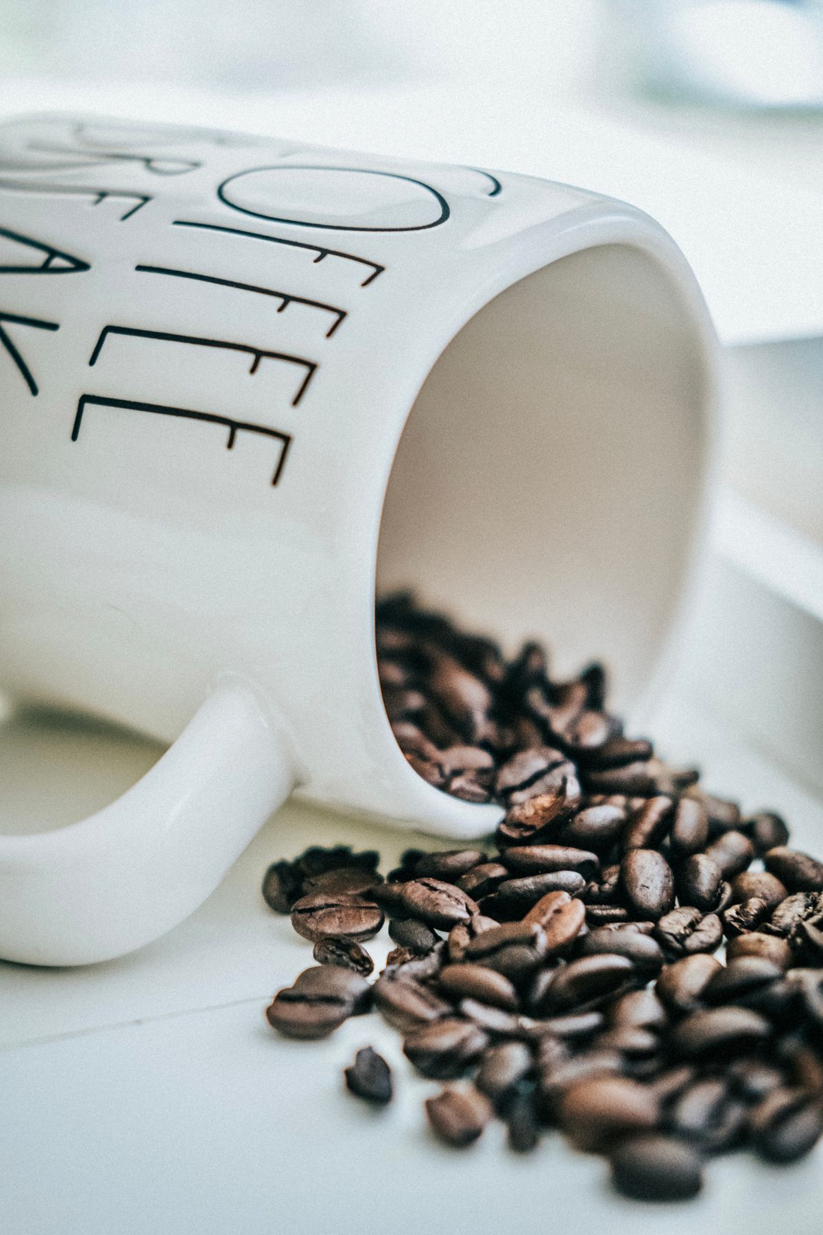 Grãos de café dentro e ao redor de uma xícara