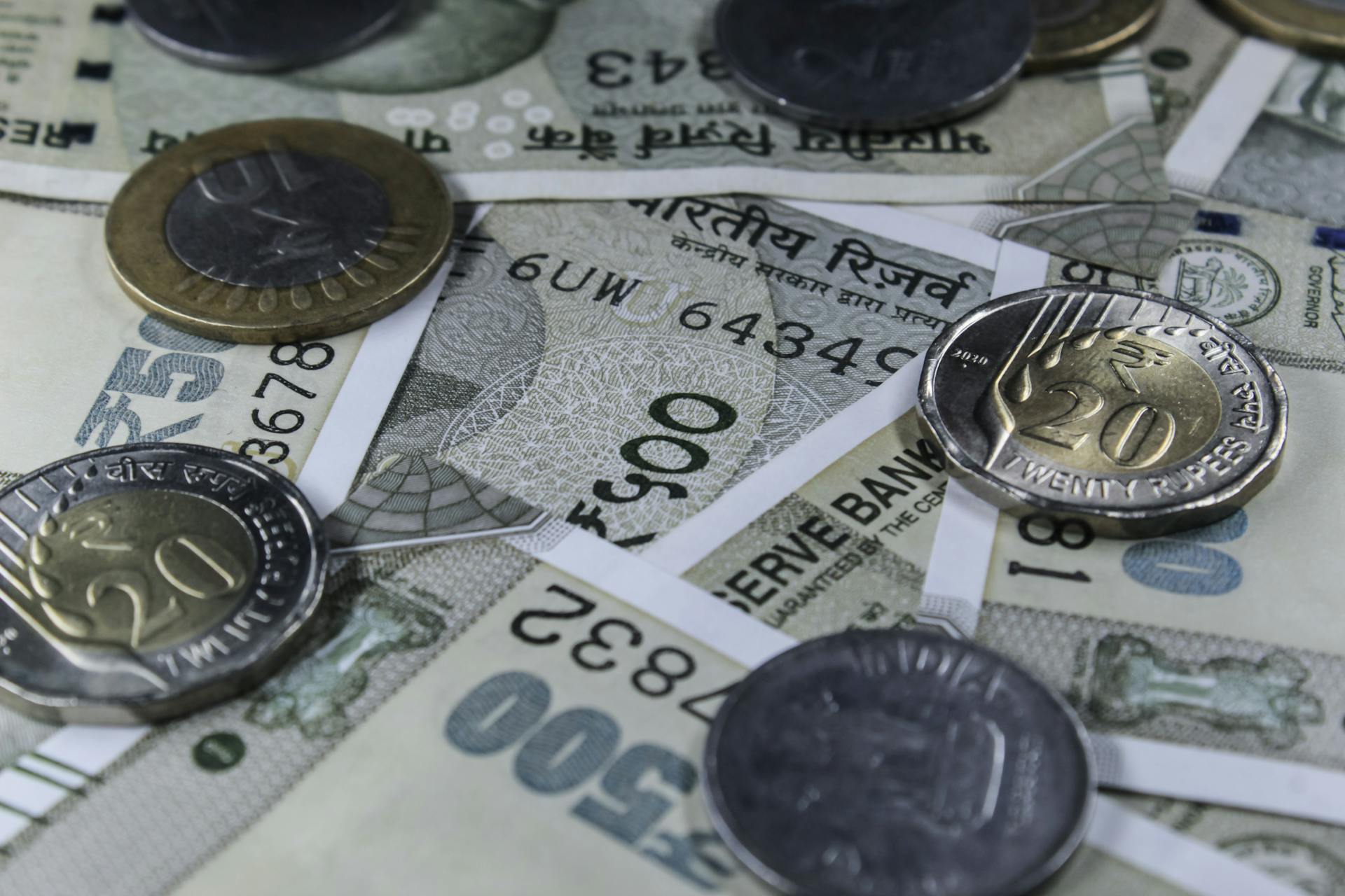 Detailed view of Indian rupee banknotes and coins, showcasing currency variety.