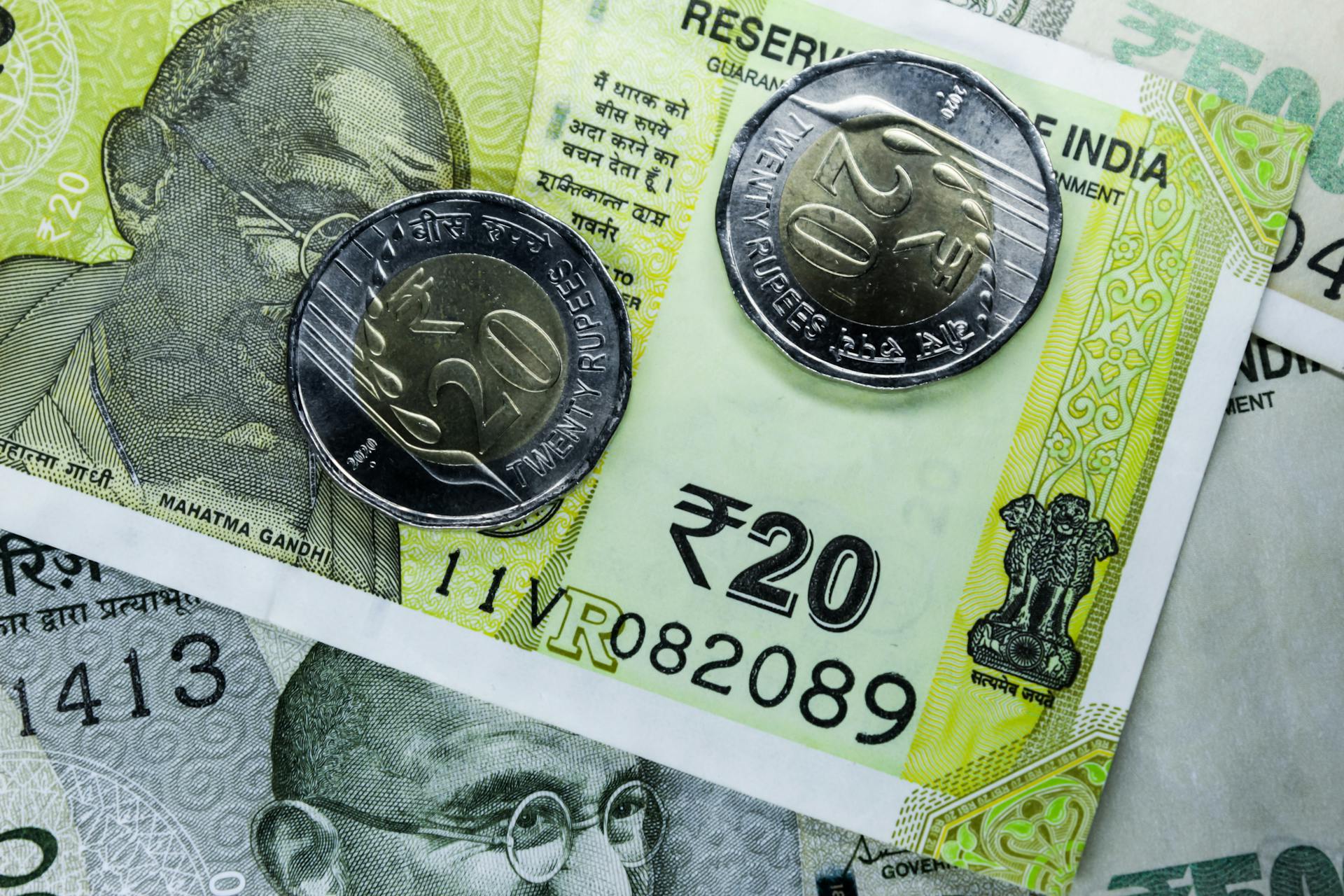 Detailed close-up of Indian rupee banknotes and coins, showcasing currency design.