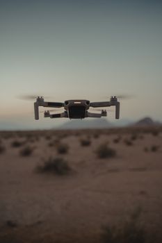 Aerial shot of a drone flying over the desert landscape in Nevada during the day.