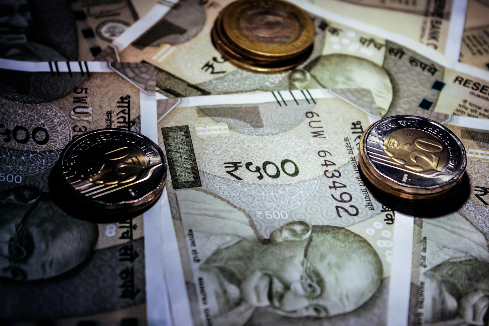 Detailed close-up of Indian currency notes and coins, featuring Mahatma Gandhi portrait.