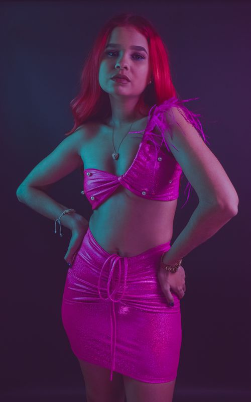 Free Studio portrait of a woman in vibrant neon fashion. Bold colors and striking pose. Stock Photo