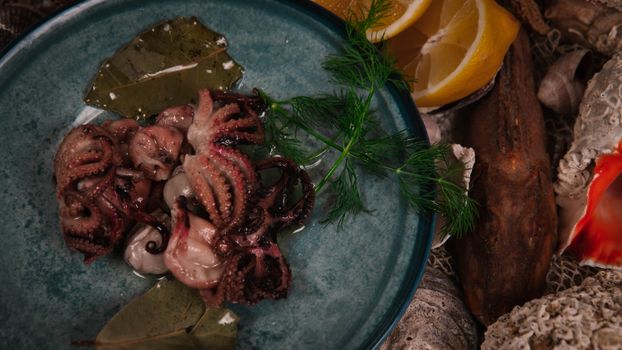 A mouthwatering octopus dish served with fresh lemons and herbs on a rustic plate.
