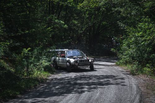 Free Dynamic rally car drifting on a winding forest road, showcasing automotive thrill and control. Stock Photo