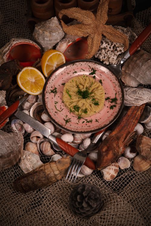 Free Rustic seafood-themed dish placed among shells and lemon slices for artistic food composition. Stock Photo