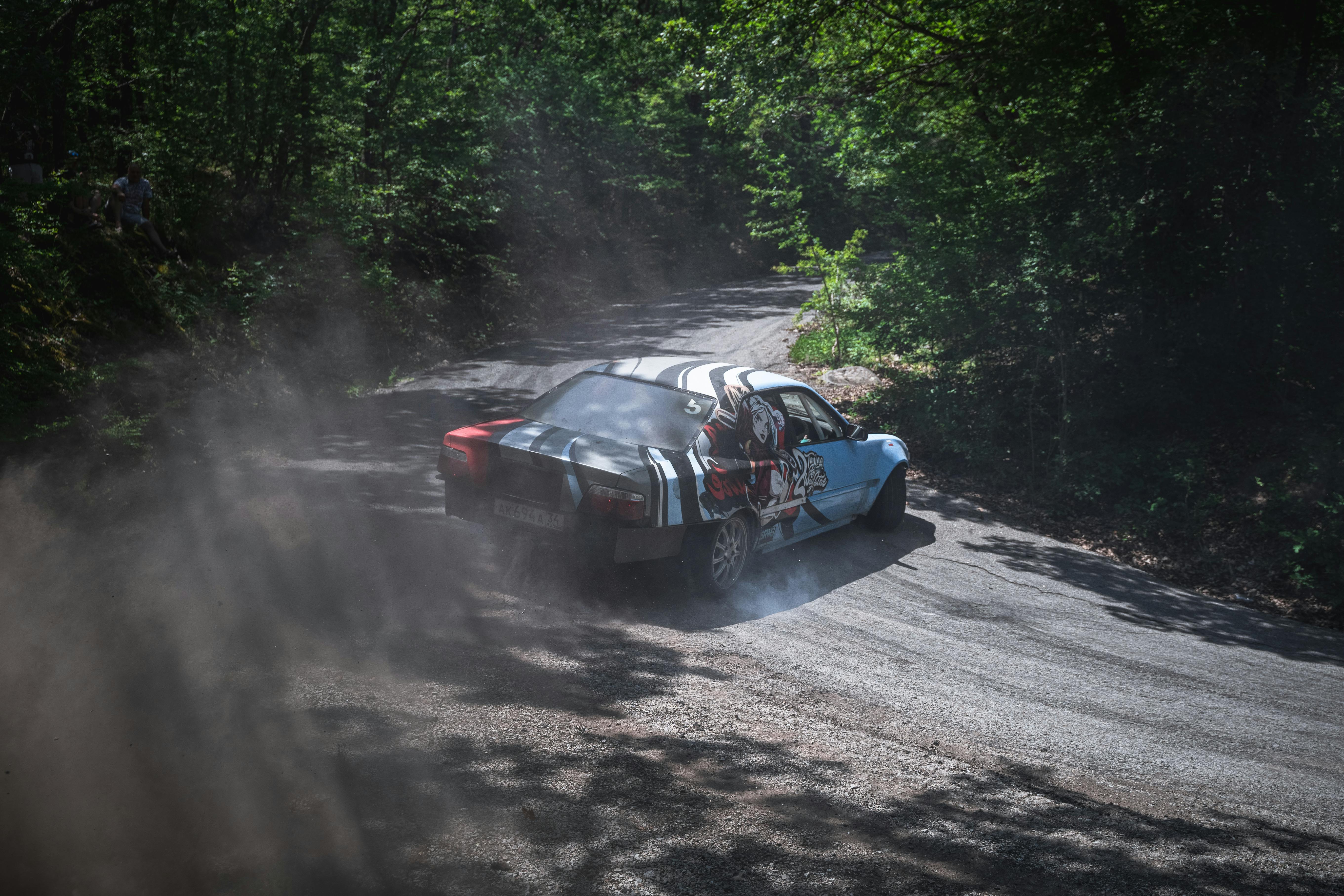 Race Car Drifting on Road through Forest · Free Stock Photo