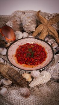Delicious Mediterranean seafood dish on a plate, garnished and surrounded by seashells.