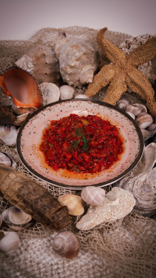 Free Delicious Mediterranean seafood dish on a plate, garnished and surrounded by seashells. Stock Photo