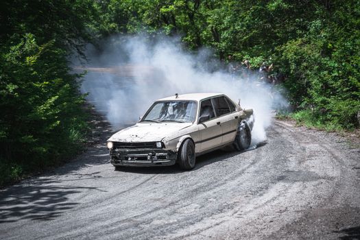 Damaged Racecar Leaving Dust on a Dirt Road Turn