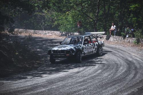 Free Car drifting rapidly around a curve on a dusty road, showcasing extreme motorsport skills. Stock Photo