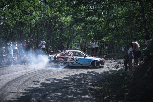 Free A thrilling drift car race in a forest with spectators enjoying the high-speed action. Stock Photo