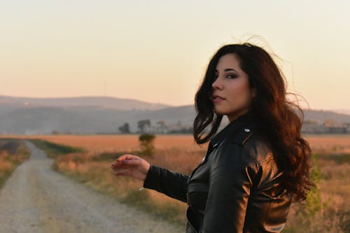 Woman Wearing Black Leather Jacket Standing on Gray Pathway