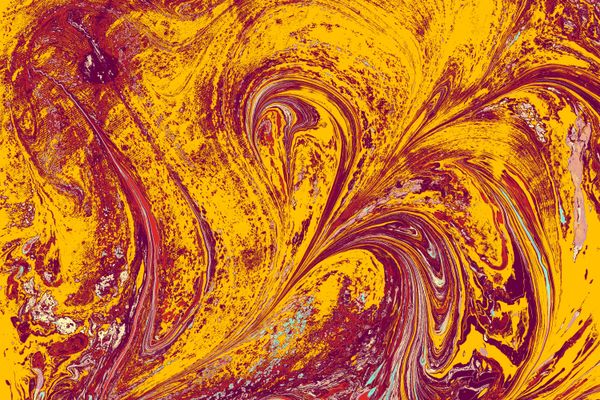Swirled marbled paper in ochre and red, photo by Turgay Koca on Pexels