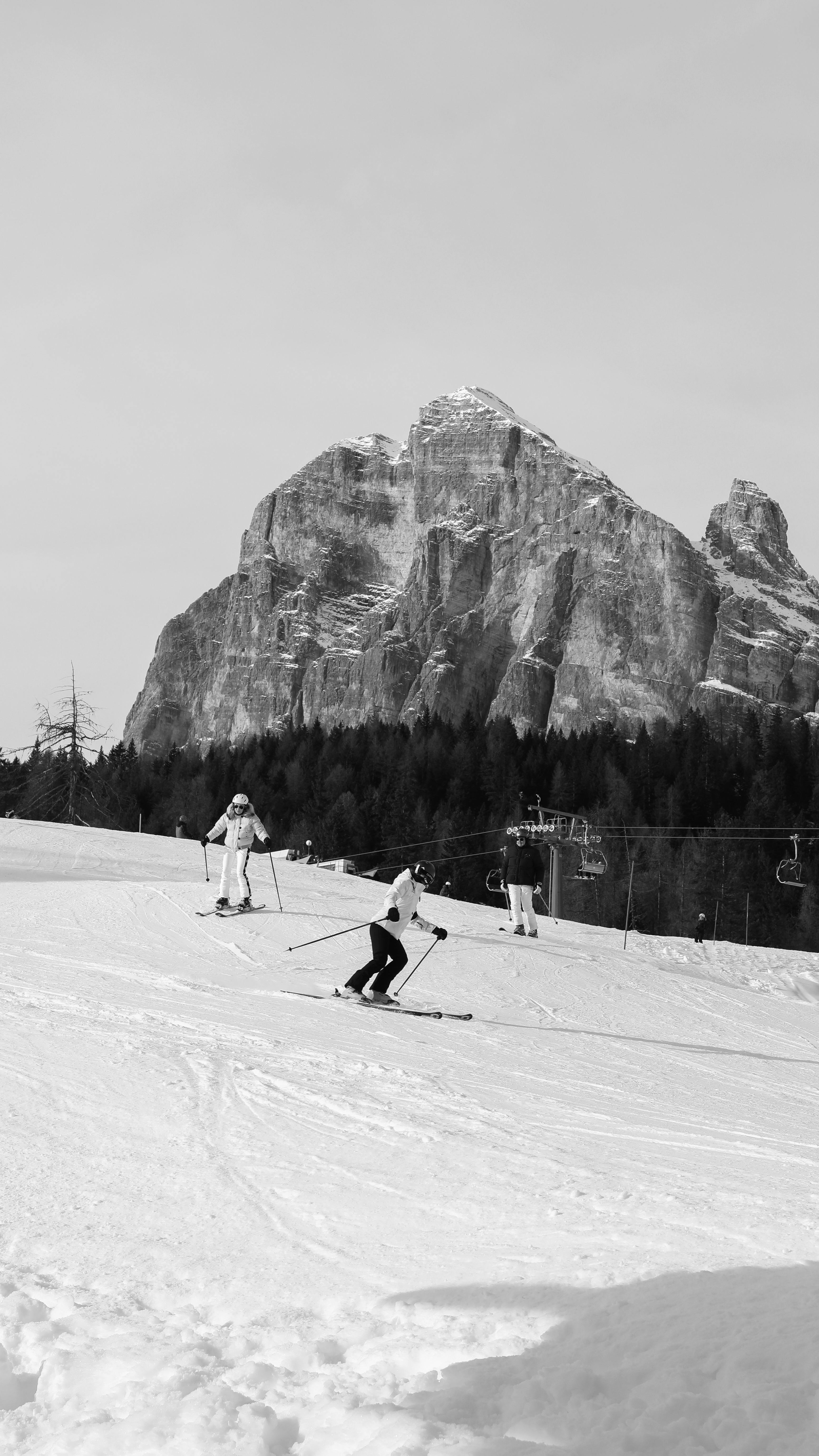 Prescription Goggle Inserts - Black and white photo of skiers on a snowy slope with a mountain backdrop.