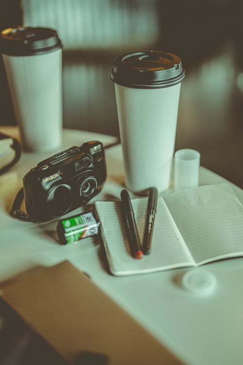 Analog Camera and Takeaway Cups on Table