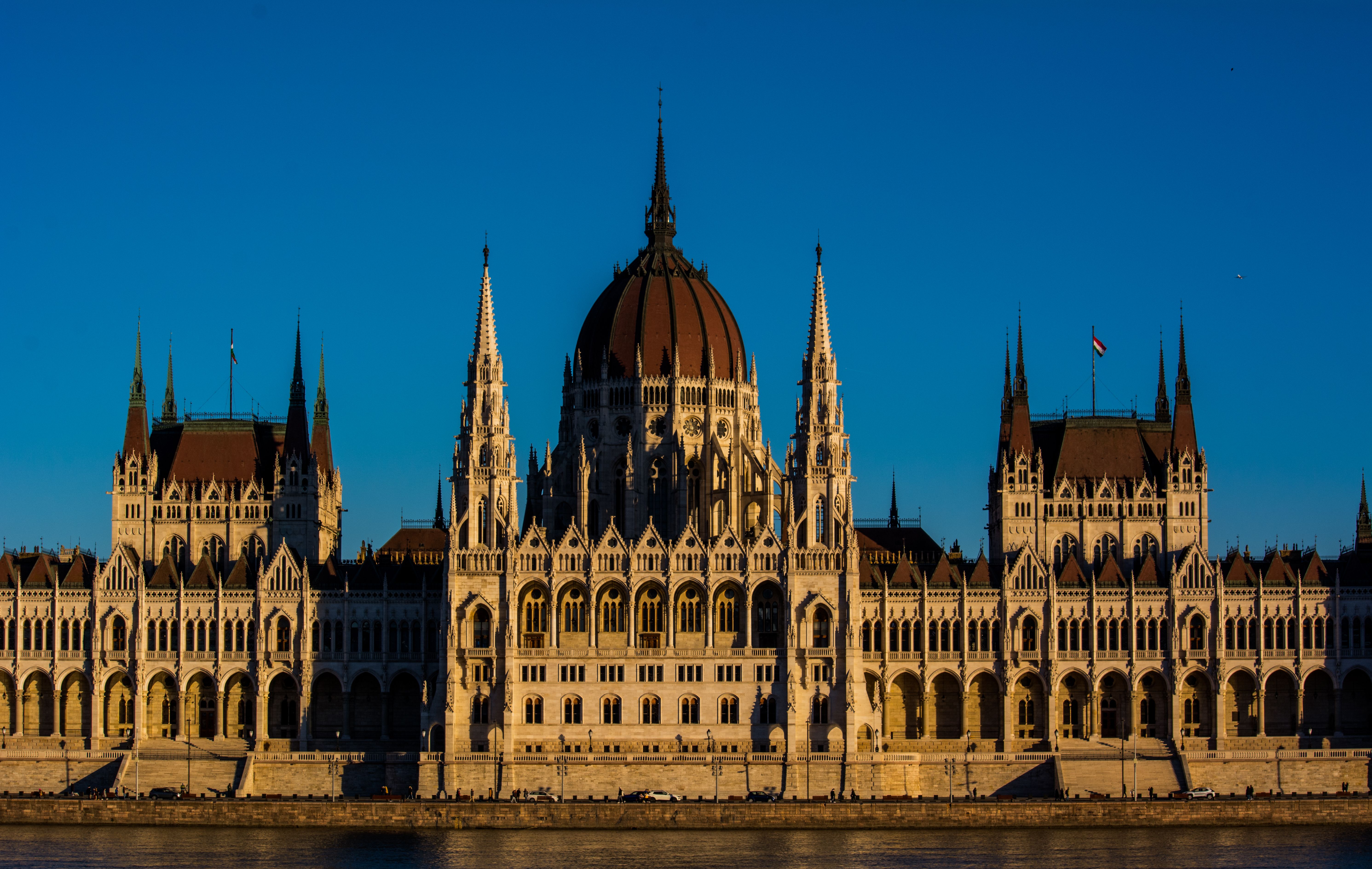 The Hungarian Parliament Building under a warm sunset light, showcasing its Gothic Revival architecture.