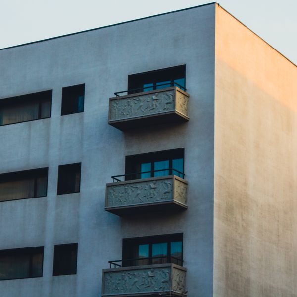 Pale modernist facade with cantilevered balconies at dusk — photo by Sakina Mammadli on Pexels