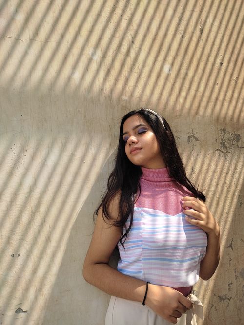 Free A fashionable young woman enjoying the sunlight with eyes closed, embracing summer vibes. Stock Photo